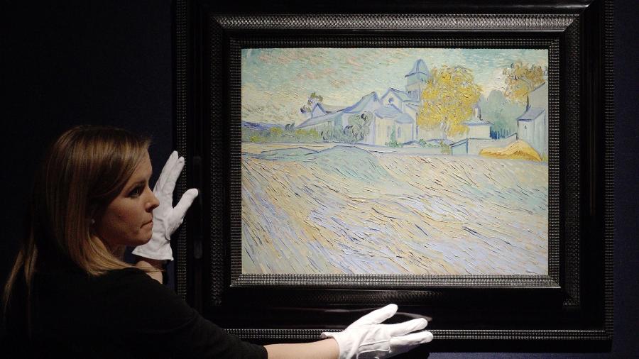 Funcionária da casa de leilão Christie"s exibe obra de Van Gogh, "Vue de l"asile et de la Chapelle de Saint-Remy", que pertencia à Elizabeth Taylor e que vai a leilão - EFE/Kerim Okten