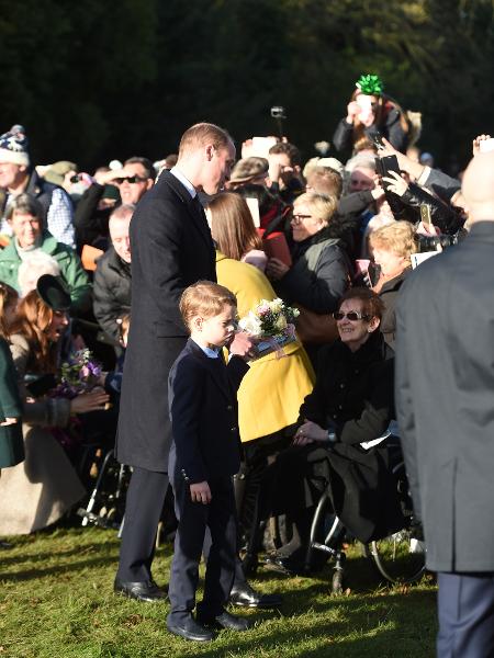 Príncipe George, de mãos dadas com o pai, príncipe William, interage com o público em evento no dia de Natal - PA Images via Getty Images - PA Images via Getty Images
