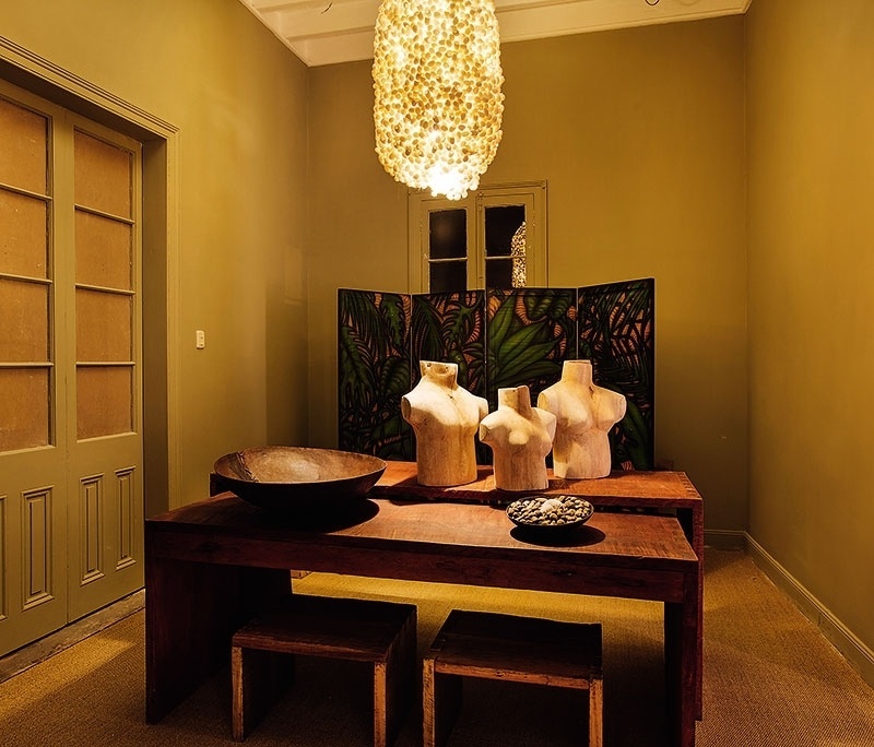 Yolanda Corvetto empregou peças inusitadas para decorar a Sala Principal: sobre a mesa de madeira estão esculturas em forma de bustos e, atrás do móvel, há um biombo estampado. Uma luminária que se assemelha a um casulo, com luz amarelada, arremata a composição com atmosfera intimista | A Casa Cor Peru (www.casacor.com.br) fica em cartaz até 8 de novembro de 2015 - Divulgação/ Casa Cor