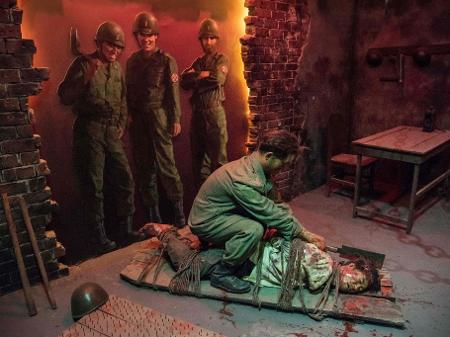 Escultura no museu de Sinchon, na Coreia do Norte, mostra soldados americanos observando um sul-coreano matar um norte-coreano - Sebastien Berger/AFP