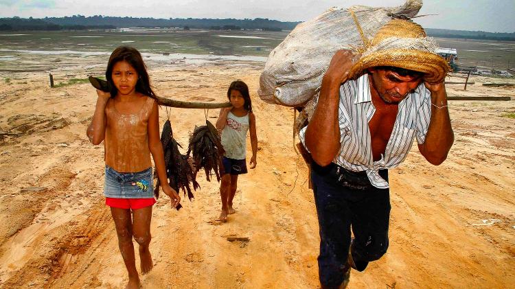 Pescador de Uarini (AM) e suas filhas caminham até a sede do município para vender peixe durante a estiagem de setembro de 2010