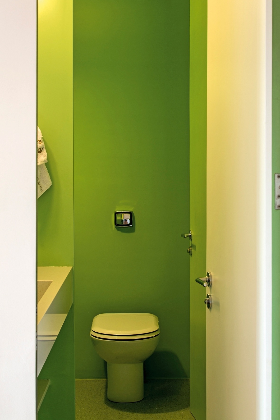 A arquitetura de interiores desenvolvida pelo escritório Pascali Semerdjian para a reforma do Apartamento FT, em São Paulo, distribuiu cores marcantes nas áreas molhadas, como cozinha, lavabo e banheiro. Na foto, o lavabo com paredes verdes serve à sala da jantar - Leonardo Finotti/ UOL