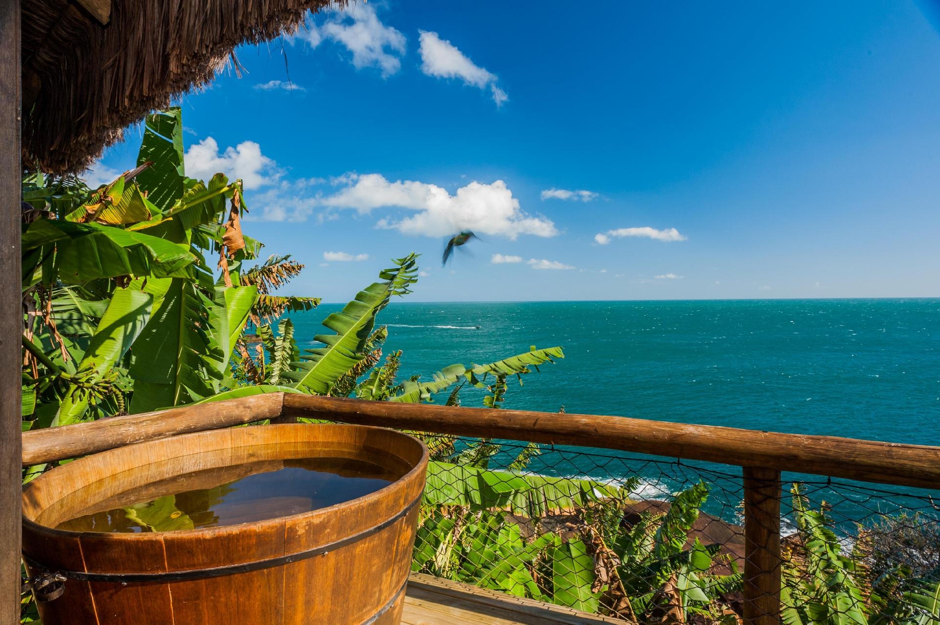 Um ofurô com uma vista de tirar o fôlego é o grande destaque desse pequeno bangalô, localizado de frente para o mar desta atração de São Paulo. Para chegar ao sul da ilha, basta descer uma escadaria entre as pedras. A casinha possui duas camas e proporciona uma enorme integração com a natureza. - Divulgação/Airbnb