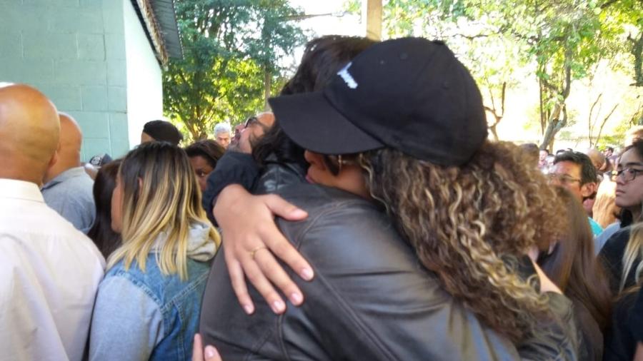 Os atores Filipe Cavalcante e Júlia Olliver se abraçam na entrada do velório do ator Rafael Miguel - Paulo Pacheco/UOL