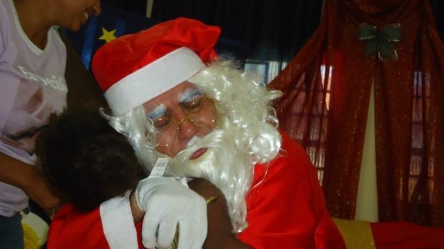 Adilson Ferreira costumava se vestir de Papai Noel para levar sacolas preparadas por padrinhos a crianças. Hoje, a viúva, Marlene, coordena o projeto - Divulgação/Projeto Centopeia