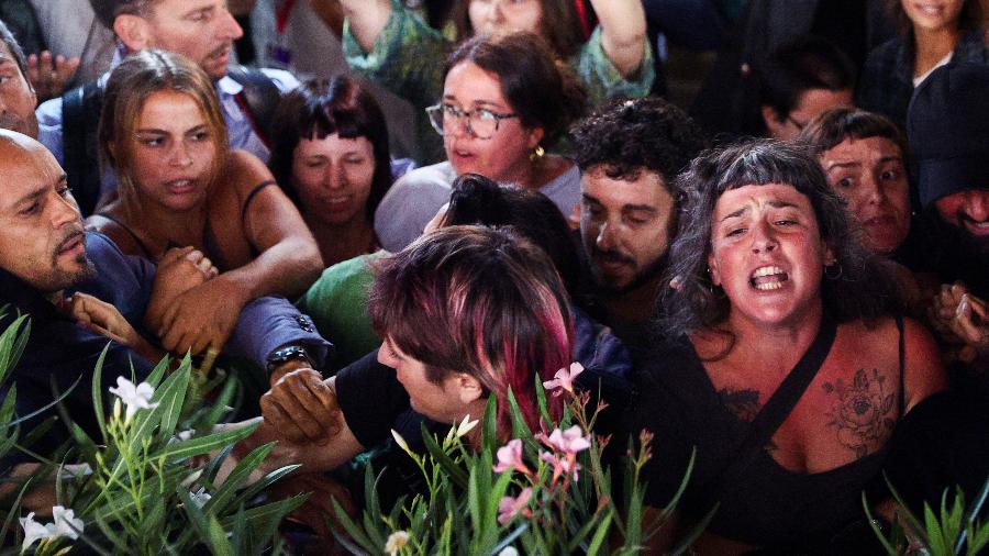 No 80º Festival de Cinema de Veneza, mulheres protestam enquanto o diretor Woody Allen chega ao tapete vermelho