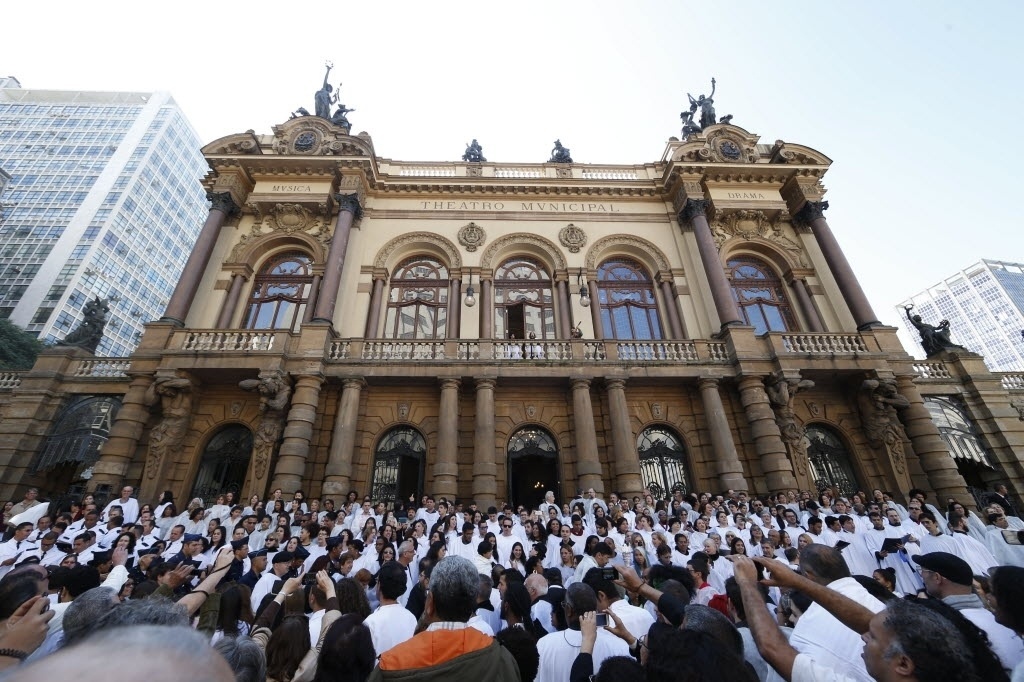 21.jun.2015 - Os corais de São Paulo tiveram pela primeira vez destaque na Virada Cultural 2015. Em frente ao Theatro Municipal, seis corais apresentaram "O Bêbado e o Equilibrista" ao lado do cantor João Bosco, na manhã de domingo (21). - Junior Lago/UOL
