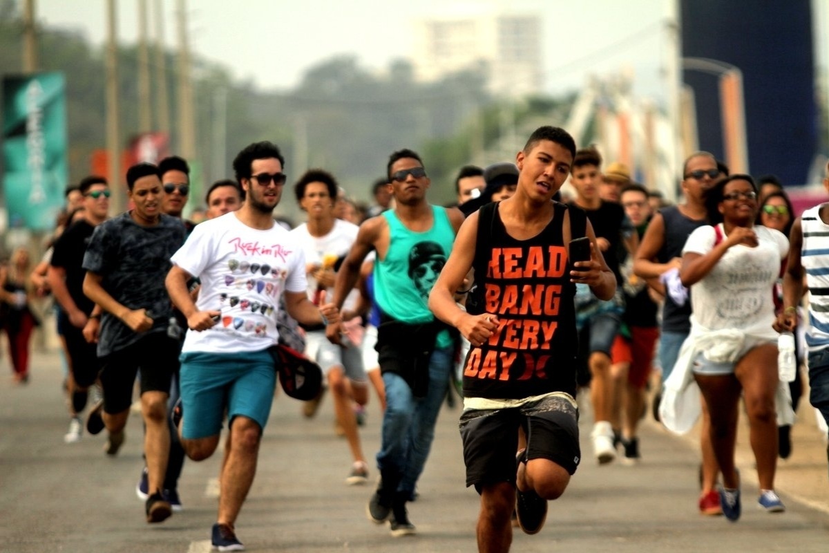 26.set.2015 - Correndo para pegar melhores lugares para assistir seus ídolos, fãs que chegaram cedo entram na Cidade do Rock para o sexto dia de shows do Rock in Rio 2015. - Marcos Ferreira/Foto Rio News