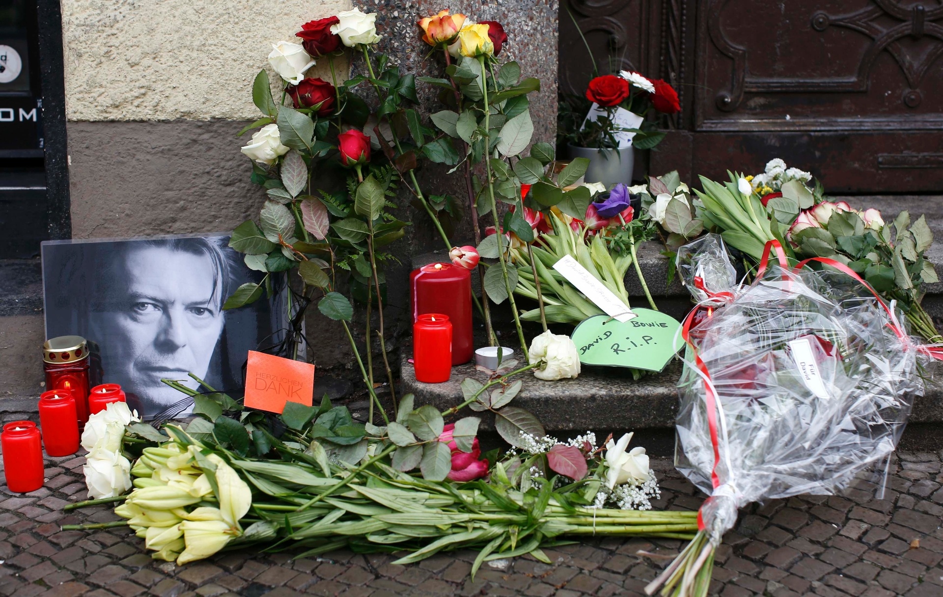 11.jan.2016 - Flores e velas são acesas ao lado de um retrato de David Bowie deixado por fãs em frente ao apartamento onde o cantor morava, em Schoeneberg, em Berlim, na Alemanha - Fabrizio Bensch/Reuters