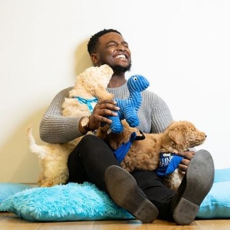Homem se diverte com filhotes de cachorro - Divulgação/Barclays