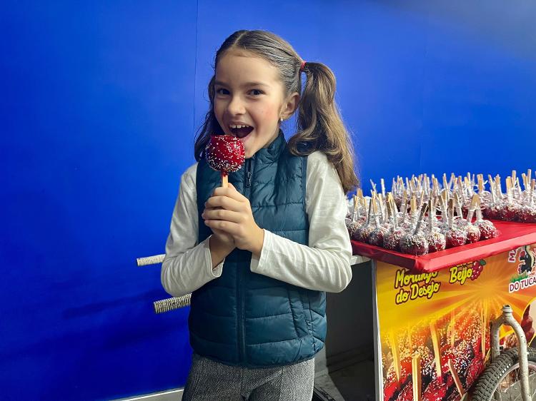 Maria Alice, 7 anos, curtindo a sua maçã do amor na sua segunda noite do Parque do Povo, em Campina Grande