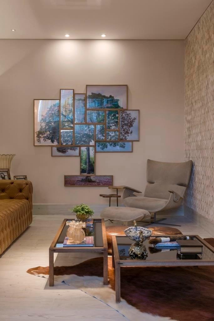 Em outro ambiente do Loft Fazenda, desenhado por Mariela Romano, os tons terrosos são vistos no sofá com acabamento em capitonê, nas duas mesas de centro com os pés de madeira e tampos de vidro e no tapete de couro. Ao lado da poltrona confortável, destaque para o quadro que retrata uma árvore - Jomar Bragança/Divulgação