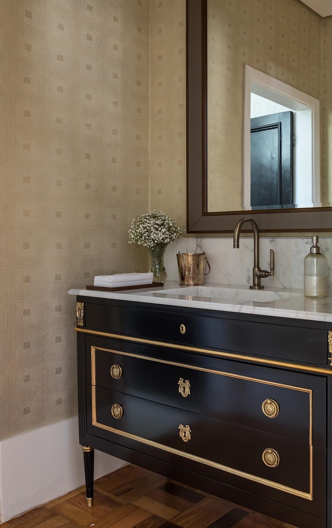 Caso o lavabo tenha algum contato com a água, a dica da In House Designer de Interiores é adotar papeis de parede de vinil, resistentes e simples de manter. As designers ainda usaram um espelho com borda diferente para arrematar o visual sofisticado - Evelyn Müller/Divulgação