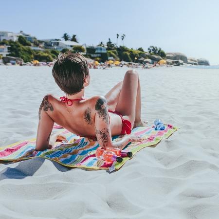 Tomar sol pode aumentar a inflamação no local da tatuagem e deve ser evitado nos primeiros 60 dias após fazer o desenho - jacoblund/iStock