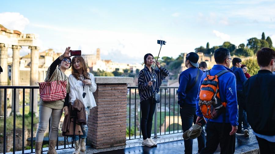 Turistas chineses tiram selfies em frente ao Fórum Romano, em Roma, Itália - Getty Images