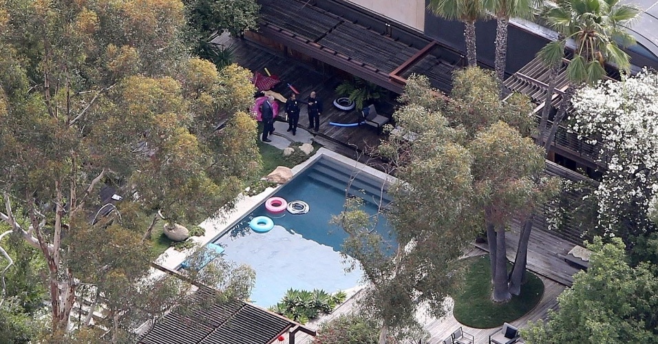 Polícia é vista próxima à piscina, no interior da casa de Demi Morre, no local onde um homem foi encontrado morto afogado