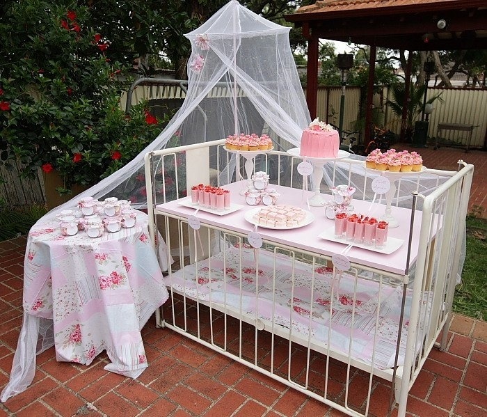 Remova uma das laterais ou então abaixe a grade, se o modelo oferecer essa possibilidade, e transforme o berço em uma mesa de festa. Use-a para deixar docinhos para os convidados se servirem. O mosquiteiro usado pelo bebê também pode ser reaproveitado para dar charme à decoração - Reprodução/Pinterest