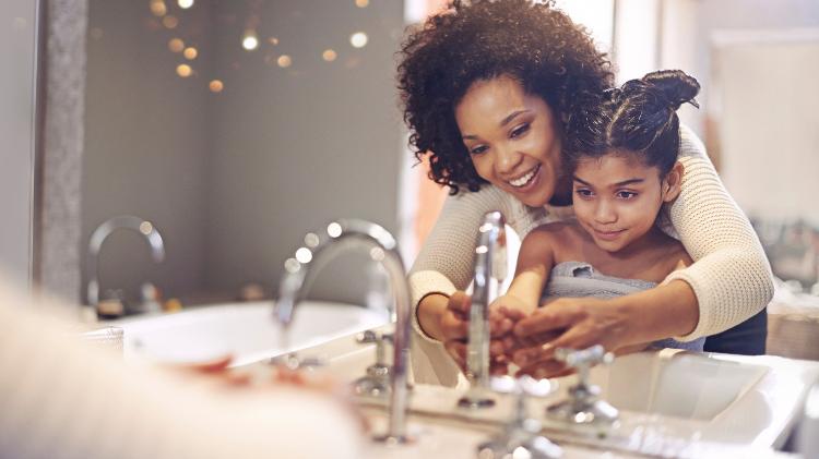 mãe e filha lavando as mãos - Getty Images - Getty Images