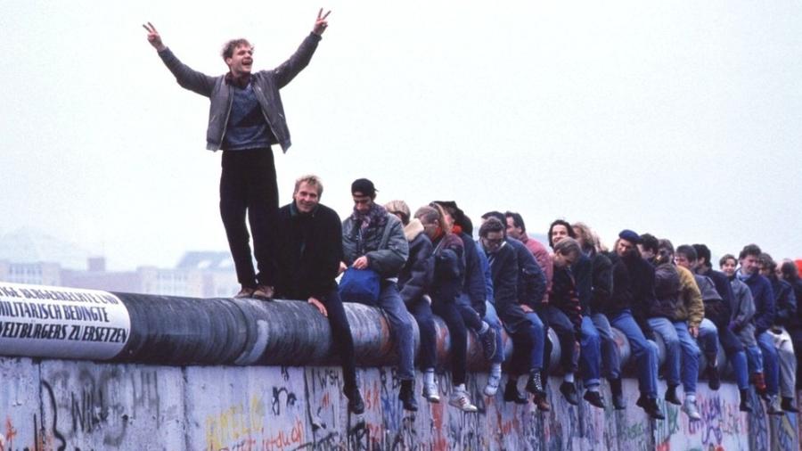 Alemães ocidentais celebram o colapso do comunismo no topo do Muro de Berlim, em 12 de novembro de 1989 - Getty Images/BBC