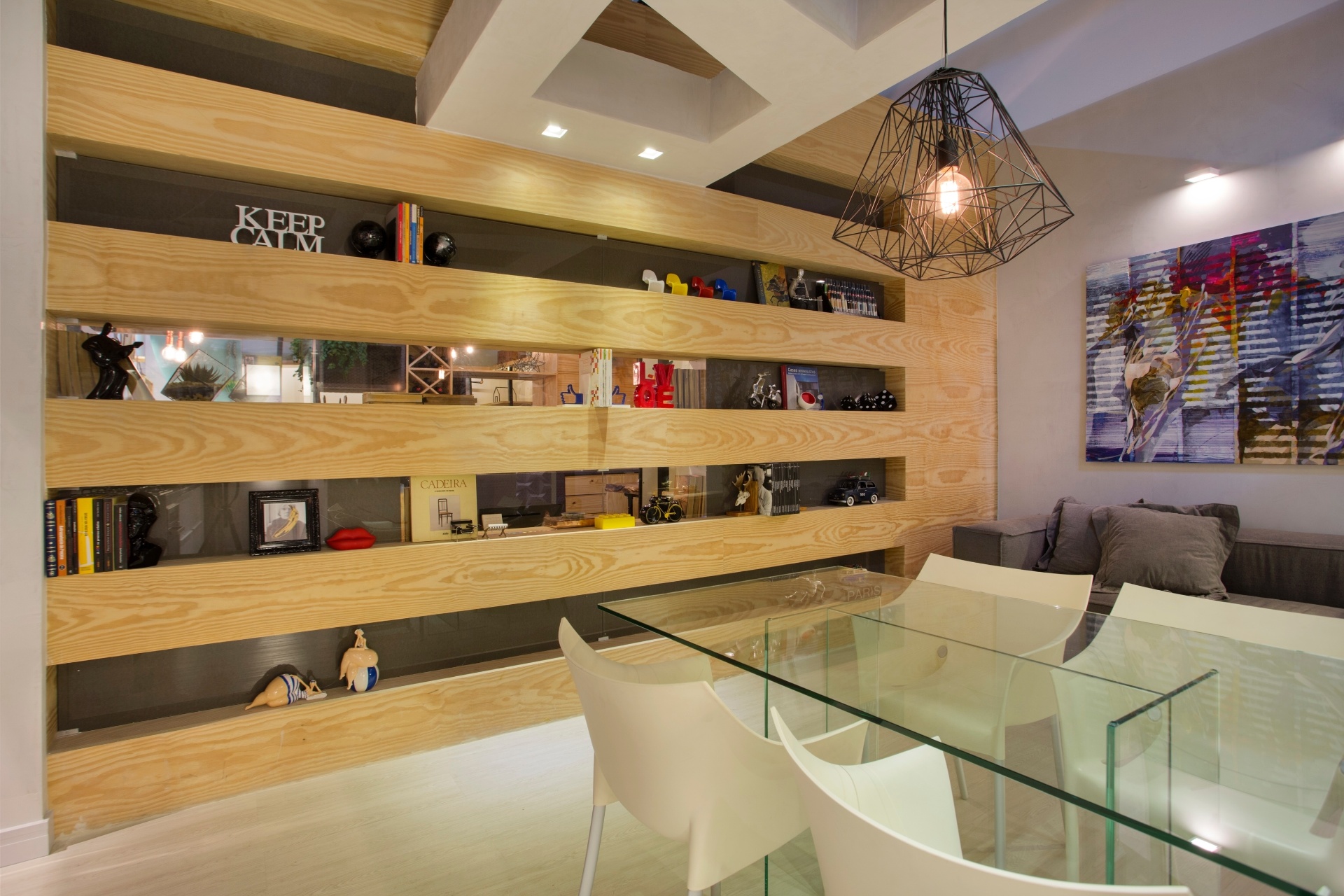 Os arquitetos Nilton Montarroyos e Estela Pinheiro sugerem uma marcenaria simples e bonita para abrigar os livros e objetos do morador. Com nichos longilíneos, a estante de madeira clara ocupa toda extensão de uma das paredes do apartamento | O projeto está exposto na Morar Mais por Menos RJ (www.morarmais.com.br) até 2 de novembro de 2015 - Denílson Machado/ MCA Estúdio/ Divulgação