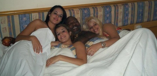 O funkeiro Mr. Catra posa na cama rodeado de três mulheres - Reprodução/Instagram - Reprodução/Instagram