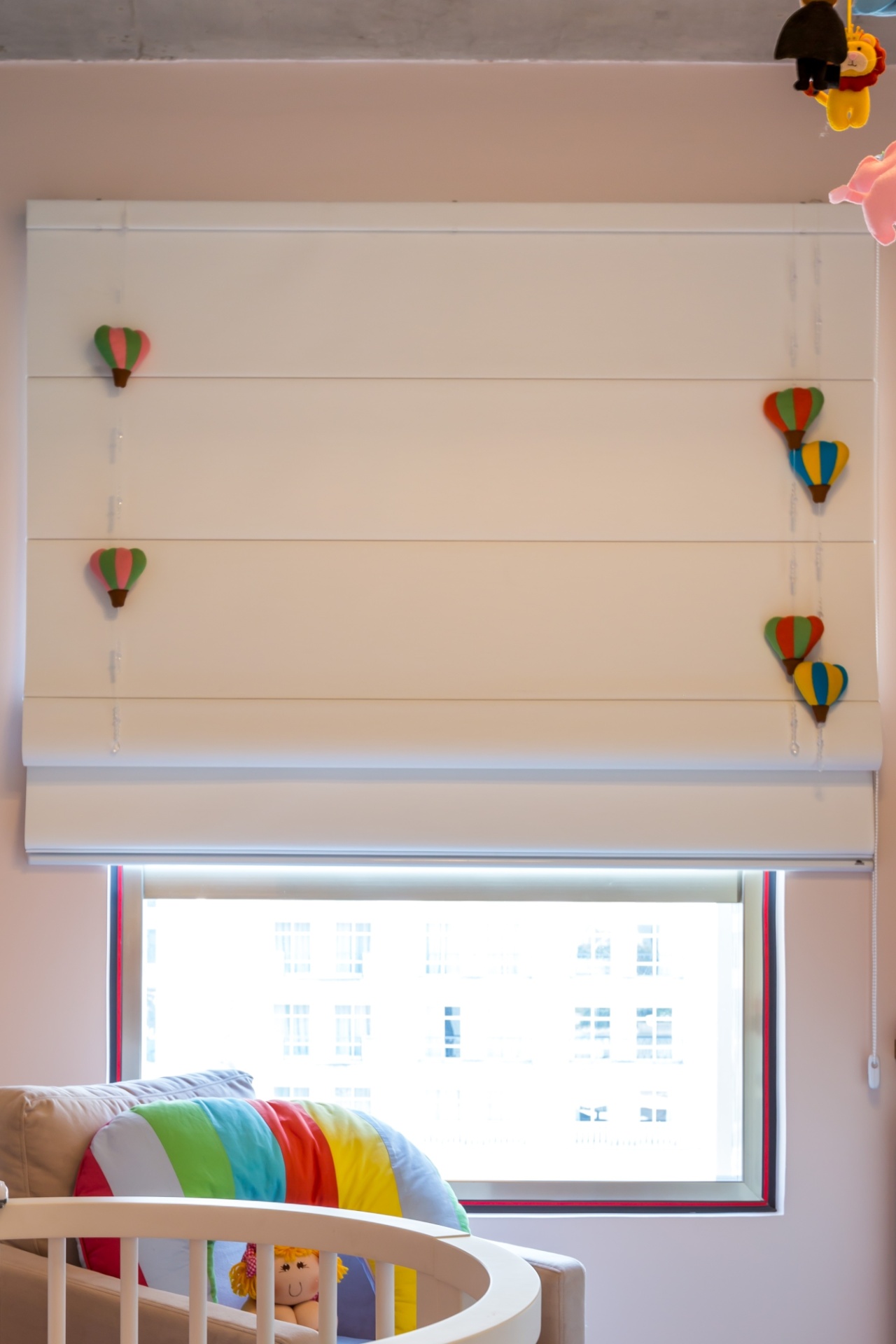 Os balões de feltro --presos a fios de nylon na persiana romana-- reforçam a atmosfera lúdica deste quarto de bebê, assinado pela By Arq & Design - Melissa Binder/Divulgação