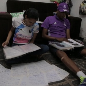 Tamires e Sabotinha observam as folhas do caderno do pai: a ideia é reuni-las a obra completa de Sabotage em livro - Reprodução - Reprodução