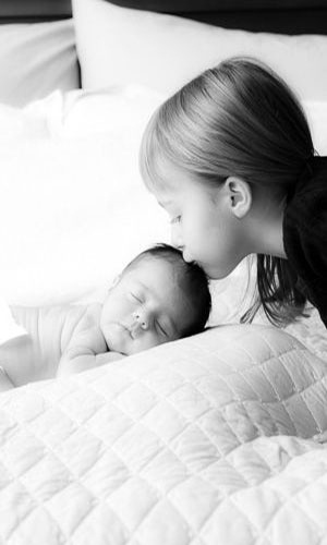 Um beijinho antes de dormir garante um sono mais tranquilo, principalmente quando vem recheado de carinho da irmã mais velha. A foto eternizando o momento também pode entrar no álbum do segundo filho - Reprodução/Pinterest J. Amado