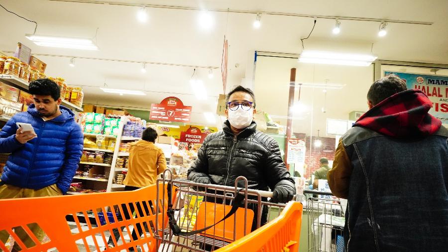 Homem faz comprar em supermercado de Nova York usando máscara de proteção contra o coronavírus - Getty Images