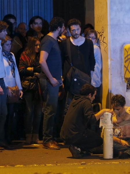 13.nov.2015 - Polícia socorre feridos na casa de shows Bataclan, em Paris, durante show da banda Eagles of Death Metal; local foi alvo de ataques - Reuters