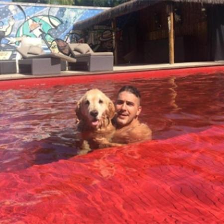 Fofura! André Marques nada em sua piscina vermelha acompanhado do cachorro - Reprodução/Instagram - Reprodução/Instagram