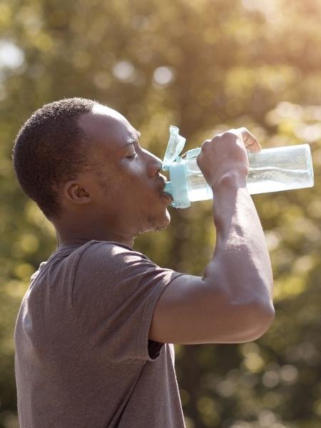 Homem jovem bebe água, hidratação, bebendo água, líquido, calor, verão, suor - iStock