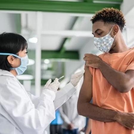 Vacina sendo aplicada em jovem - Getty Images/BBC