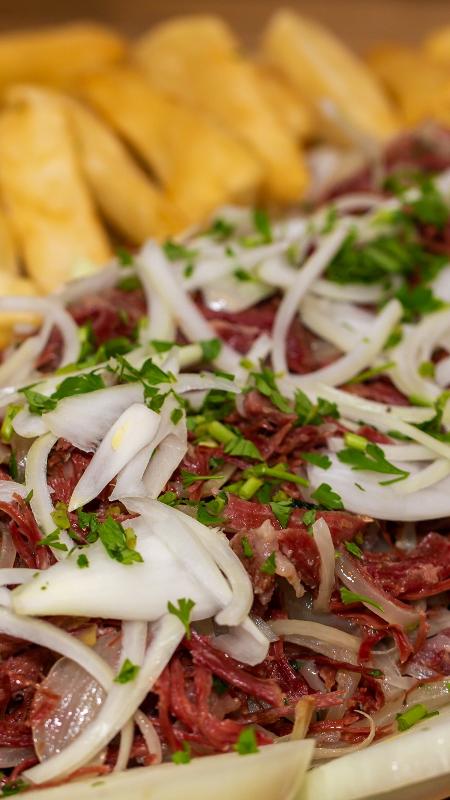 Carne seca desfiada com cebola e mandioca frita - Getty Images