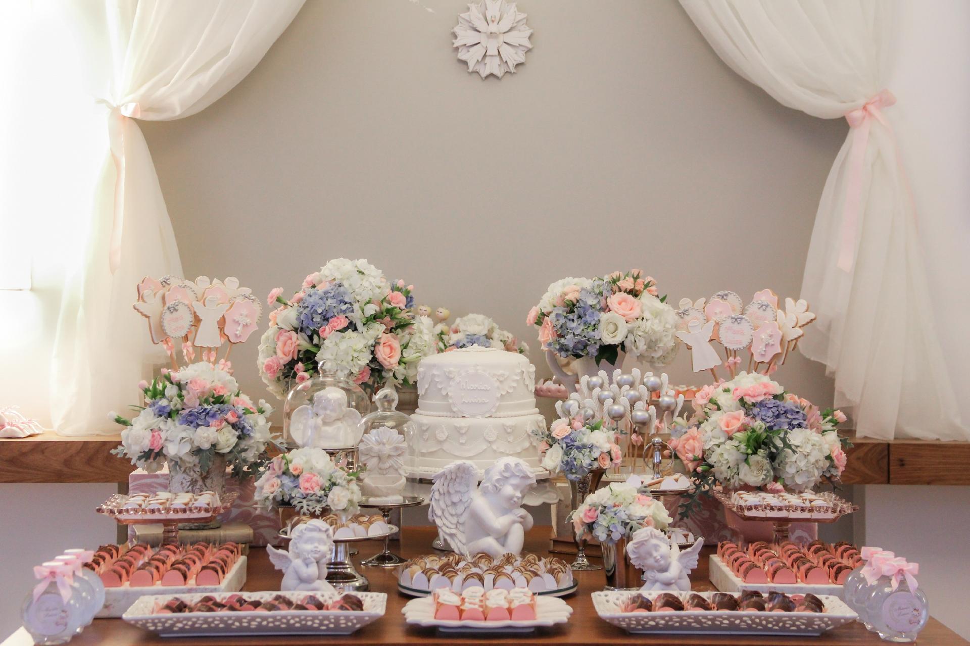 Tema clássico para a decoração de um batizado, os anjinhos saíram da capela direto para a comemoração do batismo de Maria Luísa. Para receber os 50 convidados, Fabiana Moura - Projetos Personalizados (www.facebook.com/FabianaMouraProjetosPersonalizados) foi a responsável por transformar o salão de festas do prédio dos pais da menina em um ambiente clássico e angelical - Divulgação