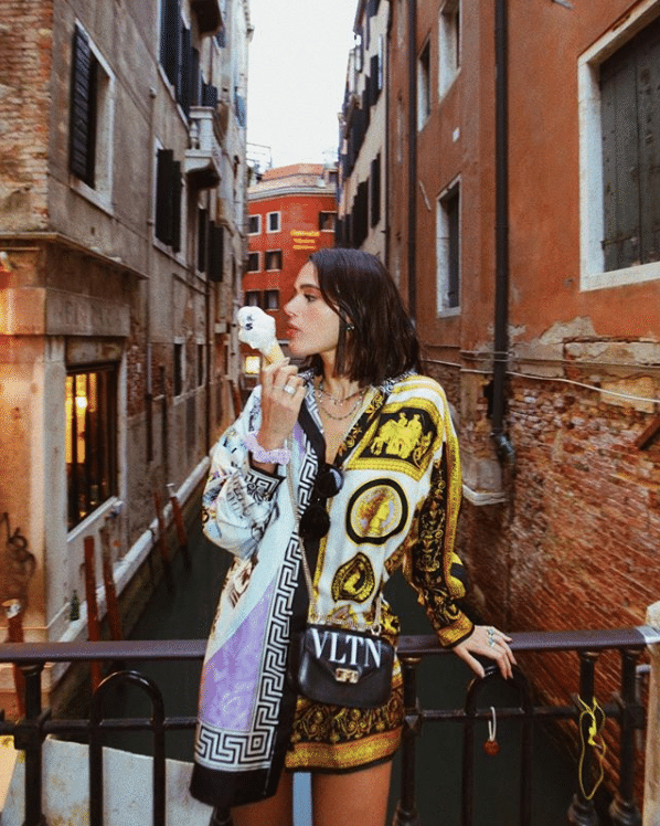 No sábado (1), a atriz passeou ainda pelas ruas de Veneza tomando gelato em uma camisa de seda da grife Versace e com bolsa transversal da maison Valentino. O acessório está avaliado em R$ 12.145. - Reprodução/Instagram