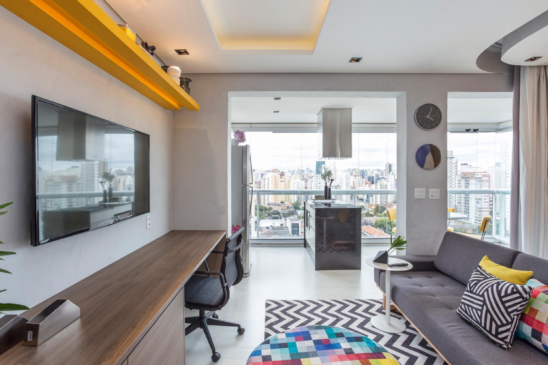 Praticidade e resistência são palavras de ordem em um imóvel de alto giro de locação. A definição dos acabamentos releva esses dois aspectos. Aqui, o designer Igor Miyahara optou por porcelanato no piso, pois "não quebra tão fácil e como manutenção basta passar um pano". Para dar um pouco de vida à sala, o tapete com estampa zigzag - Maura Mello/Divulgação