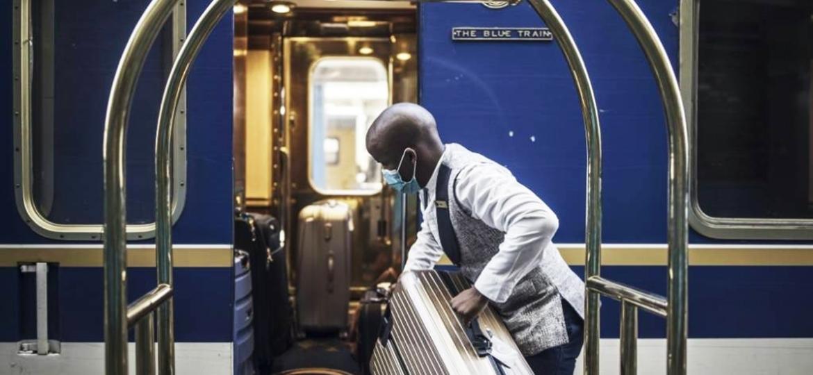 Mordomo do Trem Azul carrega a bagagem de passageiros na estação ferroviária da Cidade do Cabo - Marco Longari/AFP