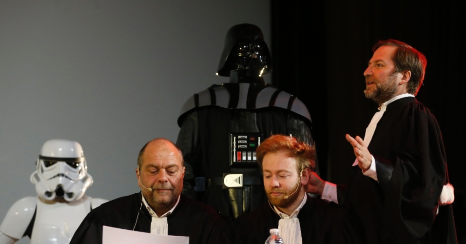 14.dez.2015 - Os advogados franceses Eric Dupond-Moretti e Antoine Vey (sentados) ouvem o companheiro Patrice Spinosi julgar o personagem Darth Vader, durante julgamente fictício, promovido no cinema Grand Rex, em Paris, França