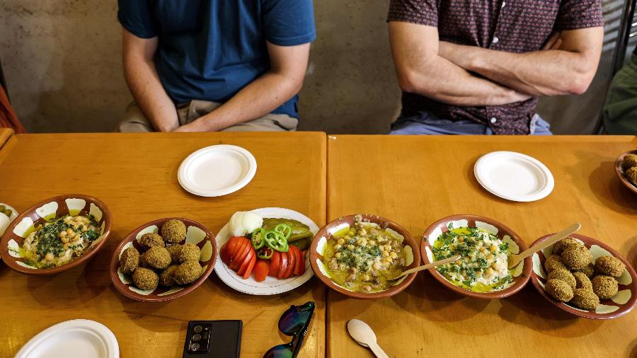 Hummus, falafel, vegetais crus, feijão-fava com grão-de-bico servidos nos restaurantes tradicionais de Jerusalém - AHMAD GHARABLI/AFP