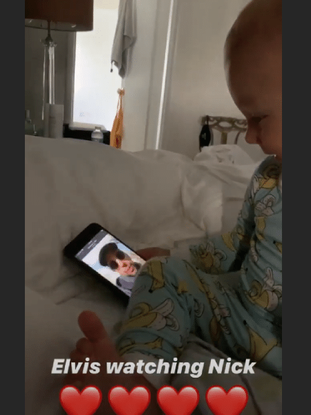 Elvis, filho do ator Nick Cordero, ri ao assistir a um vídeo do pai no celular - Reprodução/Instragram