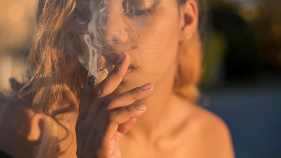 Mulher fumando cigarro de maconha. Aqui no Brasil, produto não é legalizado - Getty Images