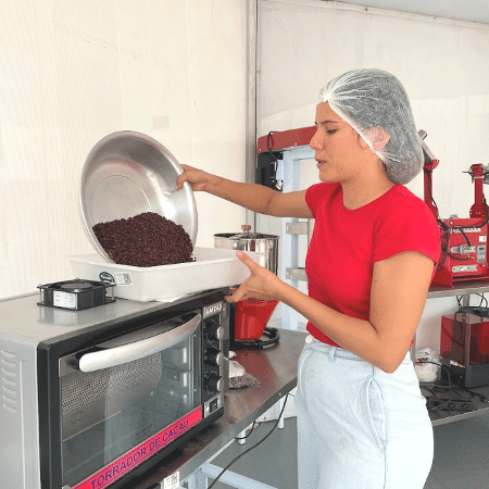 Jhanne Franco transfere os grãos de cacau torrados para uma bandeja. Ela é uma mestre-chocolateira de Rondônia e colabora com o projeto Amazônia 4.0 treinando comunidades locais na produção de chocolate e cupulate