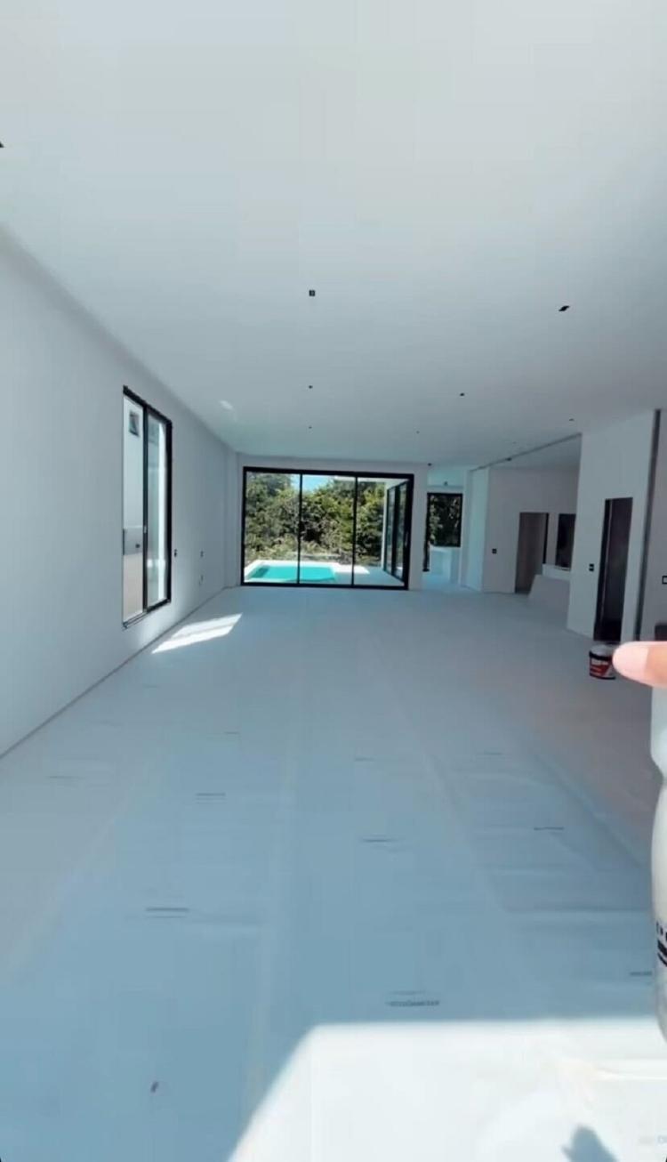 Sala de mansão de Jonas Sulzbach e Mari Gonzalez é ampla e com fundo para piscina 