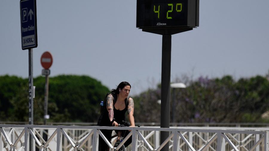 Mulher pedala em frente a termômetro marcando 42ºC em Sevilha, na Espanha, durante onda de calor Mulher pedala em frente a termômetro marcando 42ºC em Sevilha, na Espanha, durante onda de calor