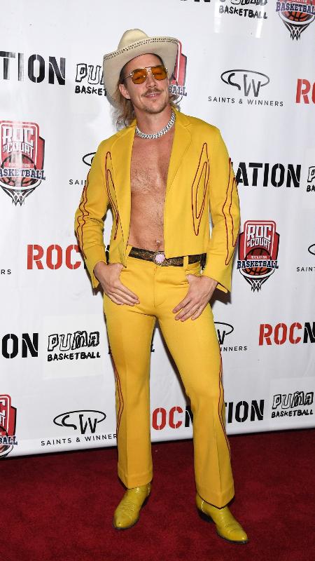 Diplo com com conjunto amarelo para visual monocromático com colar de correntes e óculos - Getty Images