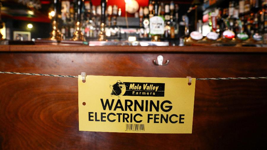 Cerca elétrica é instalada em bar para assegurar que clientes respeitem distanciamento dos funcionários na Cornualha, Inglaterra - Tom Nicholson/Reuters