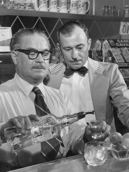 Bartender mostra ao colega como preparar gim tônica, em foto de 1958 - Denver Post via Getty Images
