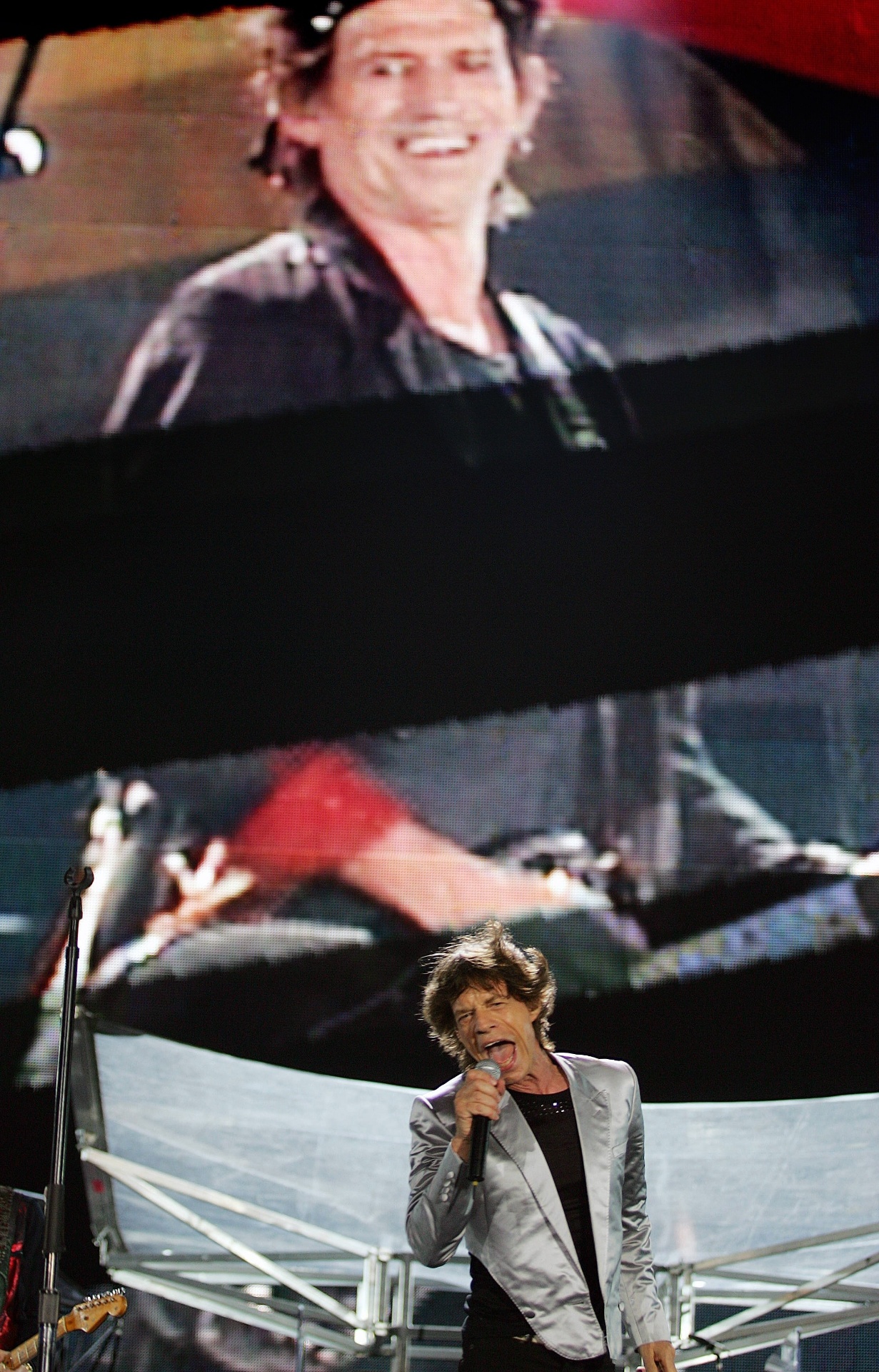 18.fev.2006 - Mick Jagger, vocalista dos Rolling Stones, se apresenta em frente a telão mostrando o guitarrista Keith Richards durante show da banda na praia de Copacabana - Vanderlei Almeida/AFP