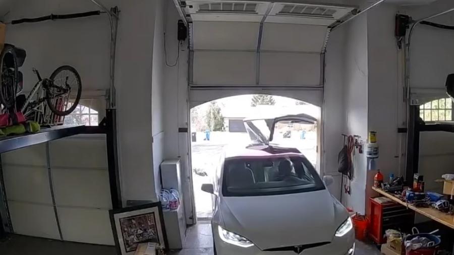 Mulher dobra porta de Tesla Model X entrando em casa - Reprodução